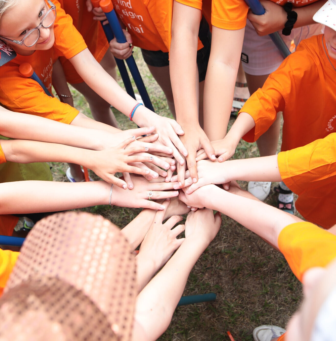 Nofam teamwork - Children putting hands together.